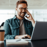 Man on the phone and working on the computer.